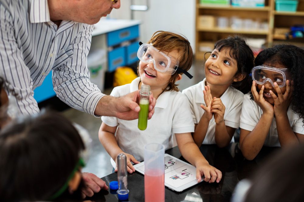 Professor ensinando alunos do ensino fundamental em laboratório de química.