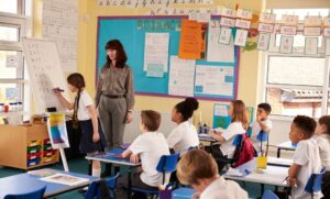 alunos resolvendo problemas de matemática com apoio da professora.